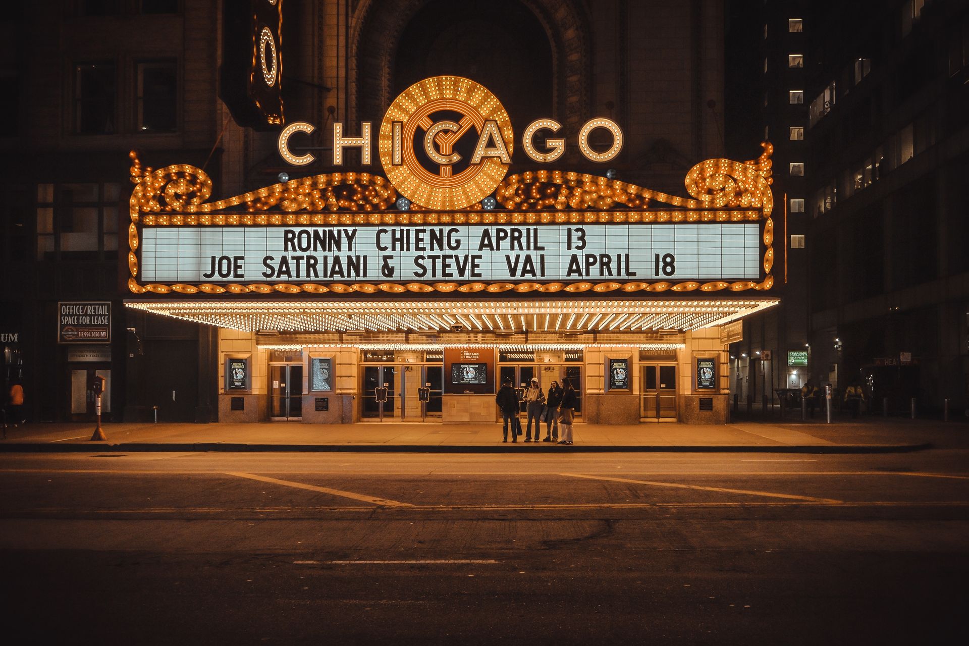 Capturing the iconic Chicago Theater marquee illuminated at night with upcoming show listings.