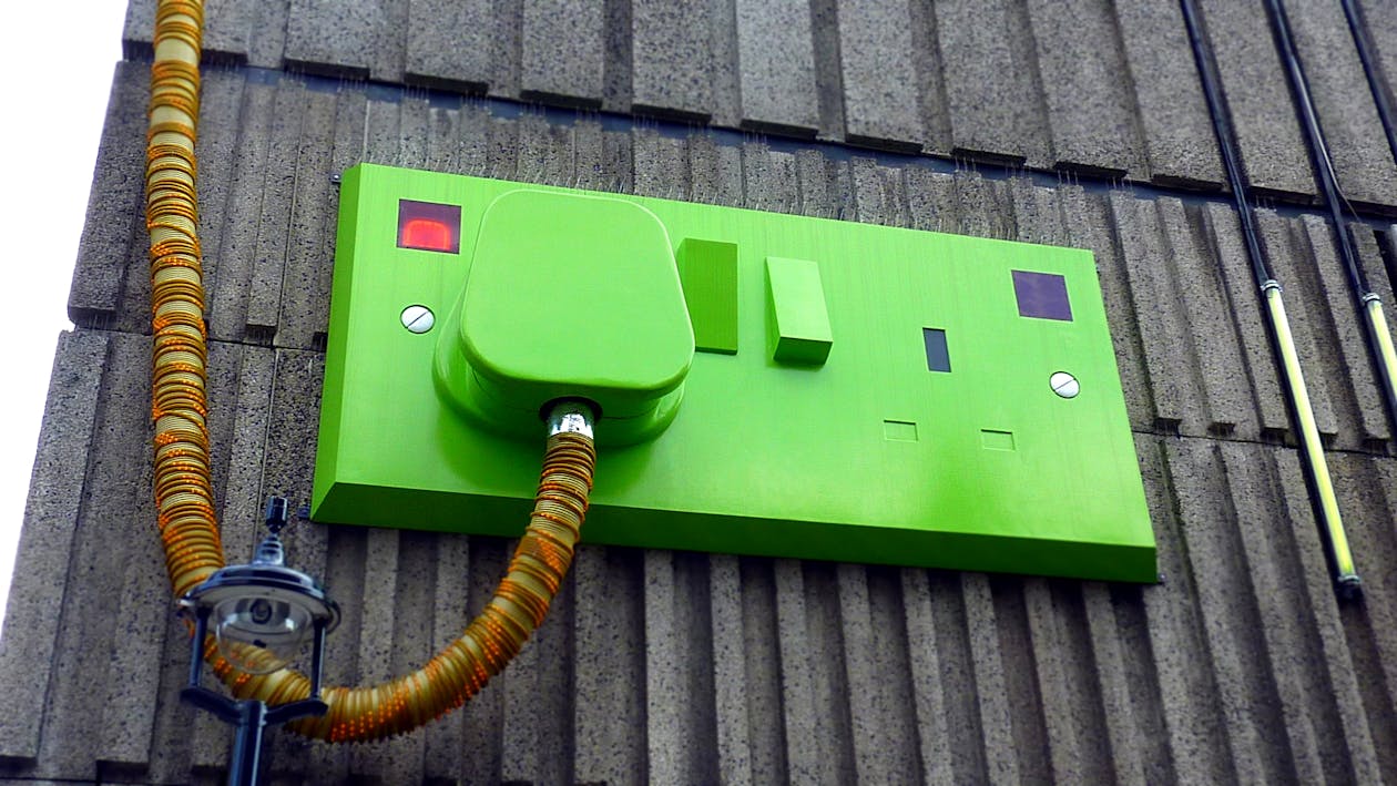 Free Green Rectangular Corded Machine on Grey Wall during Daytime Stock Photo