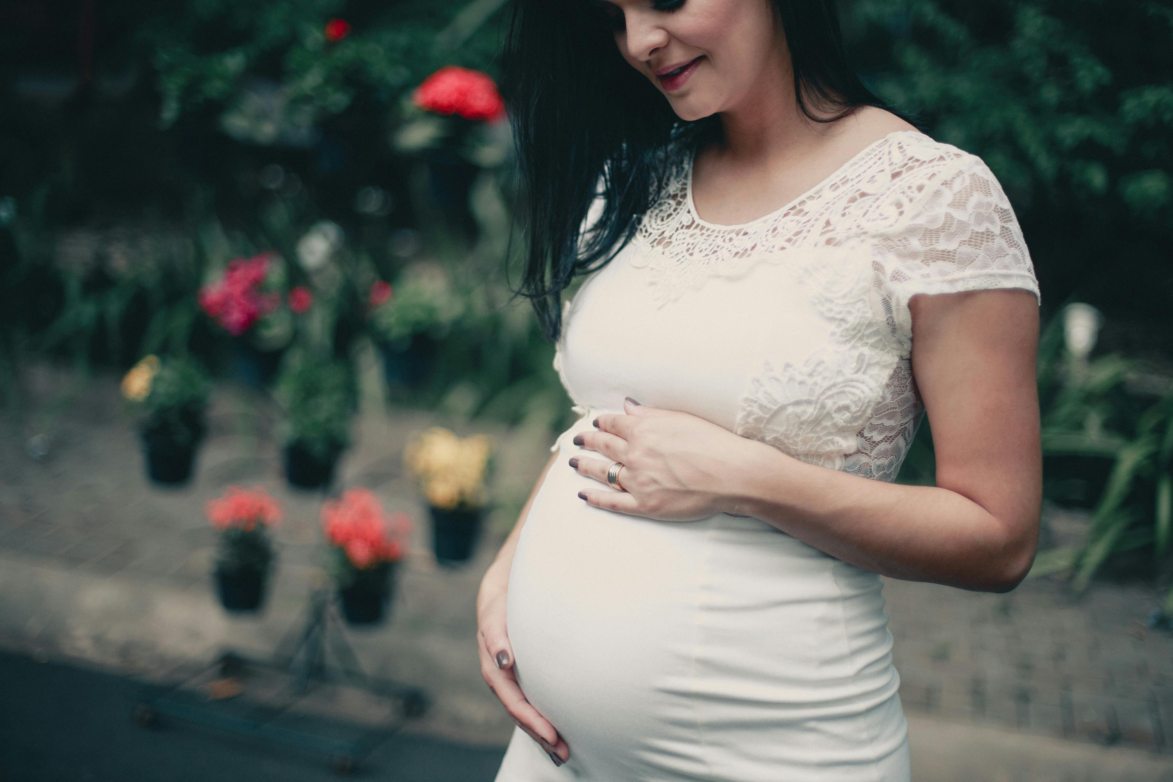 Closeup of pregnant woman wearing maternity girdle. Isolated over