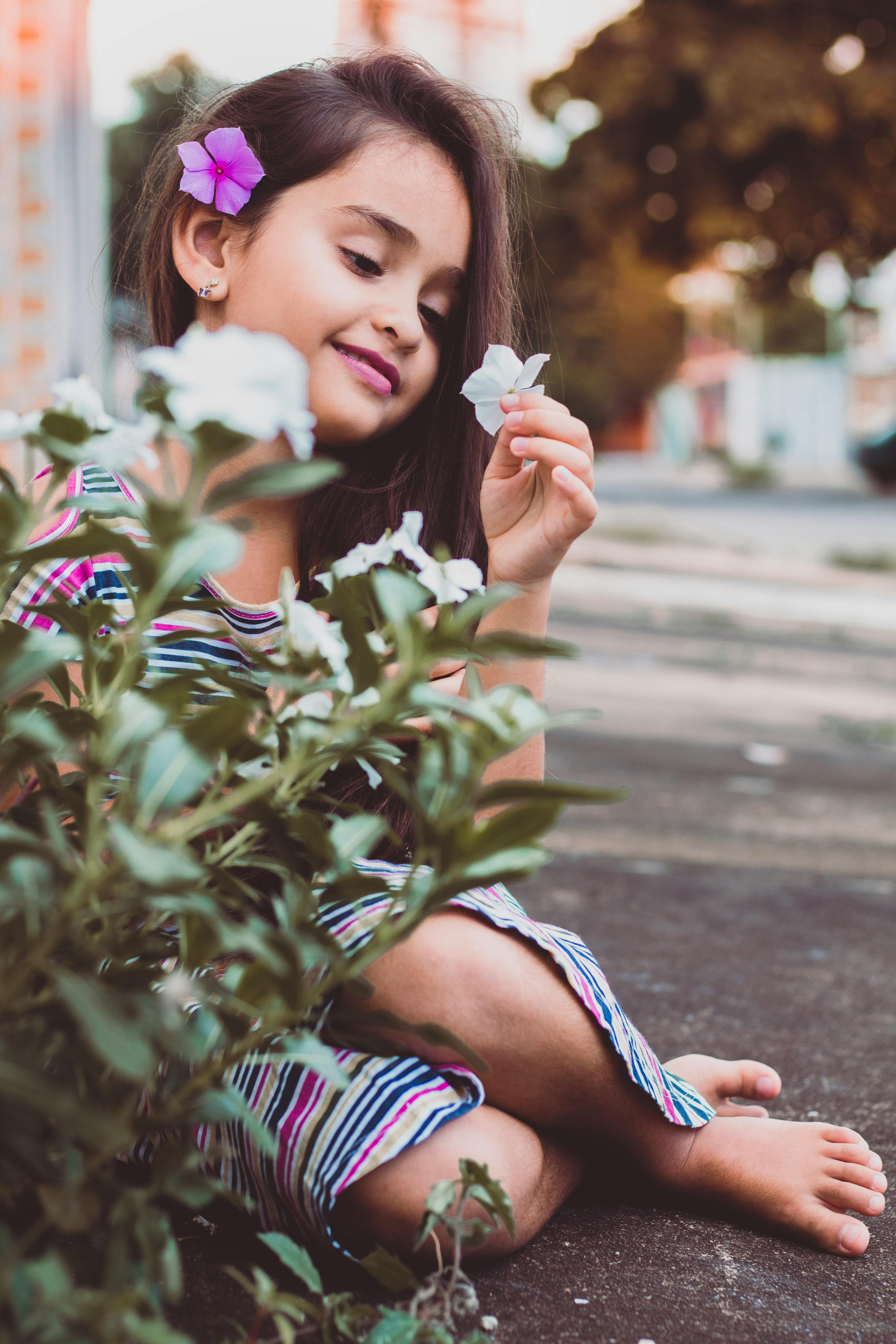 Nude little girl sitting back to us on a light background Stock Photo