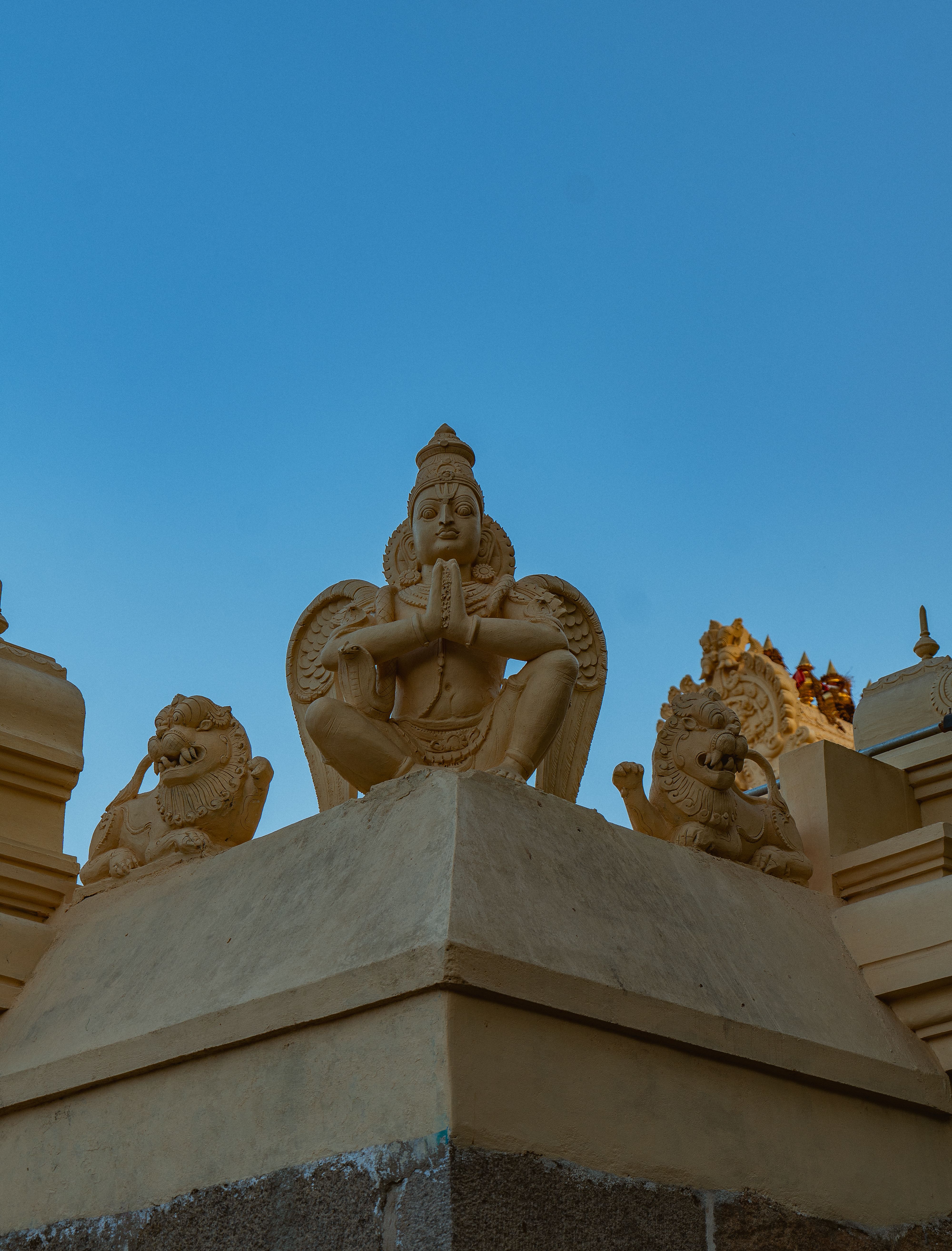 Close-up view of traditional Indian temple sculptures with clear blue sky in the background.