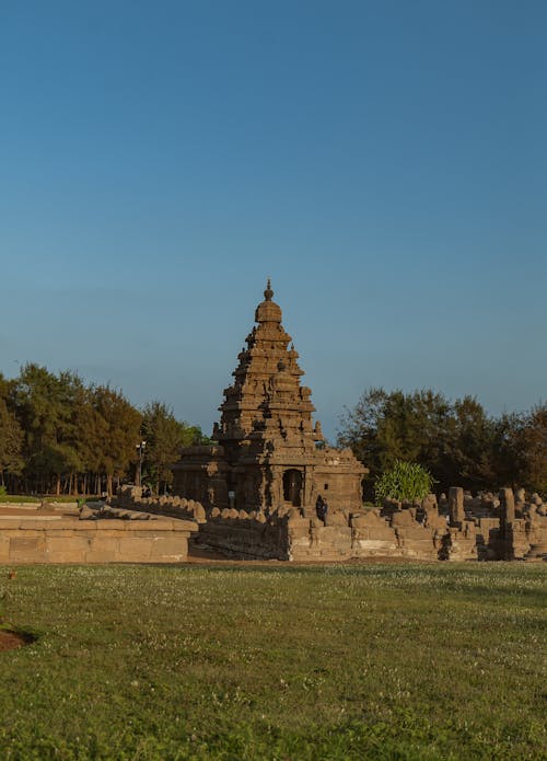 The temple is surrounded by green grass and trees