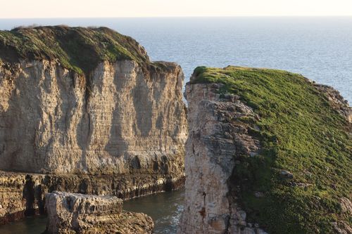 Free Scenic view of rocky cliffs with greenery against a tranquil sea backdrop. Stock Photo