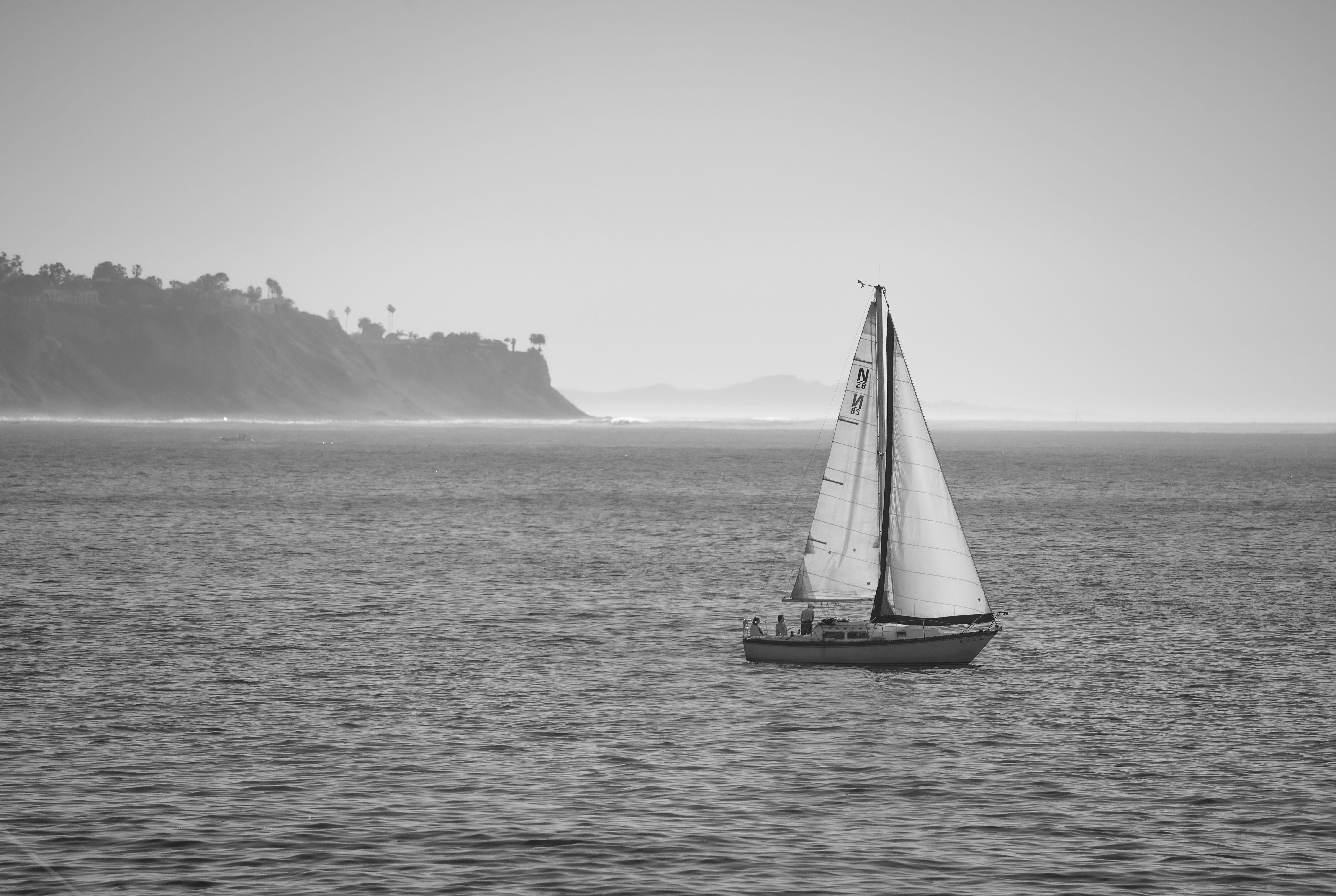 Black and White Photo of a Sailboat Sailing near the Shore · Free Stock ...