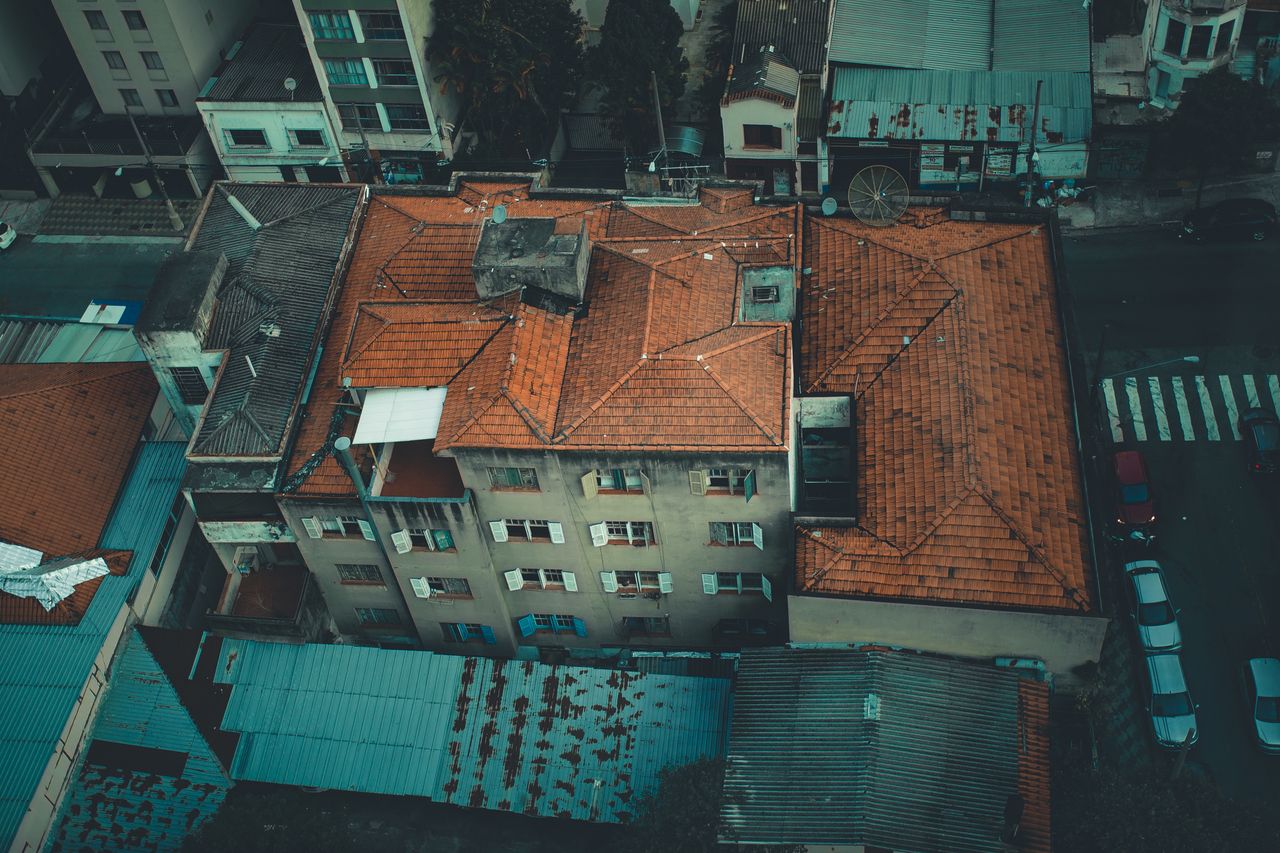 Aerial shot of urban rooftops showcasing a residential area with intricate roof patterns.