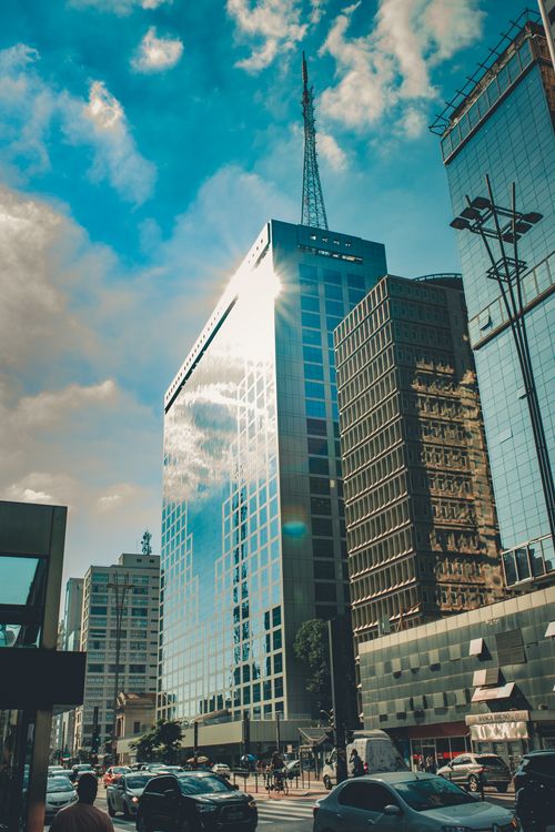 Free Vibrant cityscape featuring modern skyscrapers and busy street under a clear blue sky. Stock Photo
