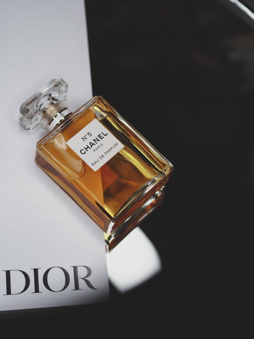 A bottle of dior perfume sitting on top of a magazine