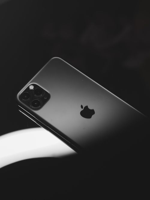 Free Stylish black smartphone with a sleek design and triple camera lens on a dark background. Stock Photo