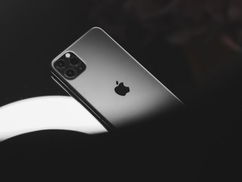 Free Minimalist photo of a smartphone on a reflective surface captured in black and white. Stock Photo