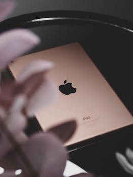 A sleek iPad reflecting flowers on a glossy surface, captured in Paris.