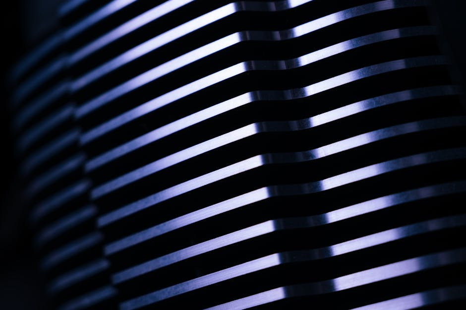 Close-up of metal fins with blue lighting, creating a mesmerizing abstract pattern.
