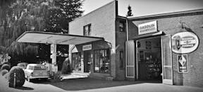 黑白照片中的老式加油站与老爷车