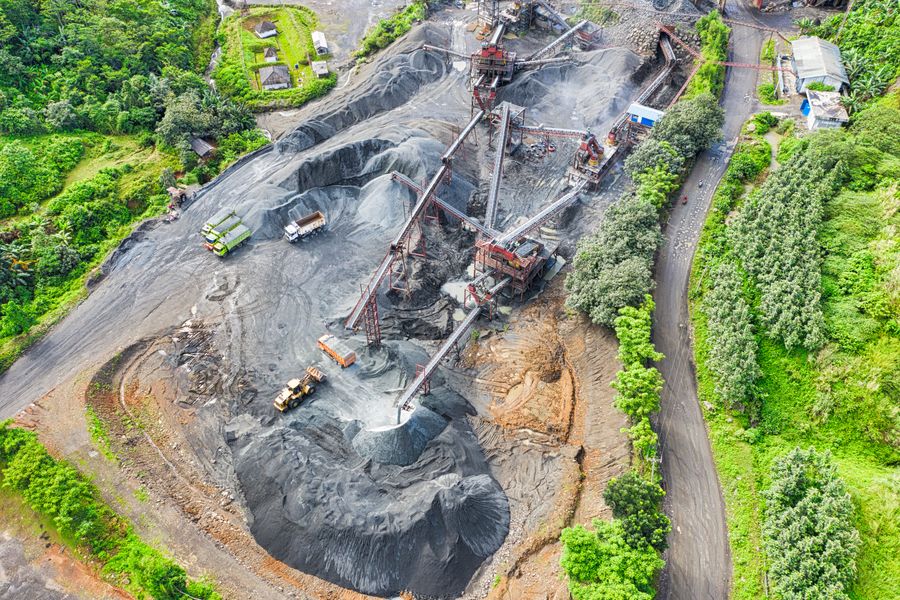 Aerial view of heavy mining trucks on an open earth site