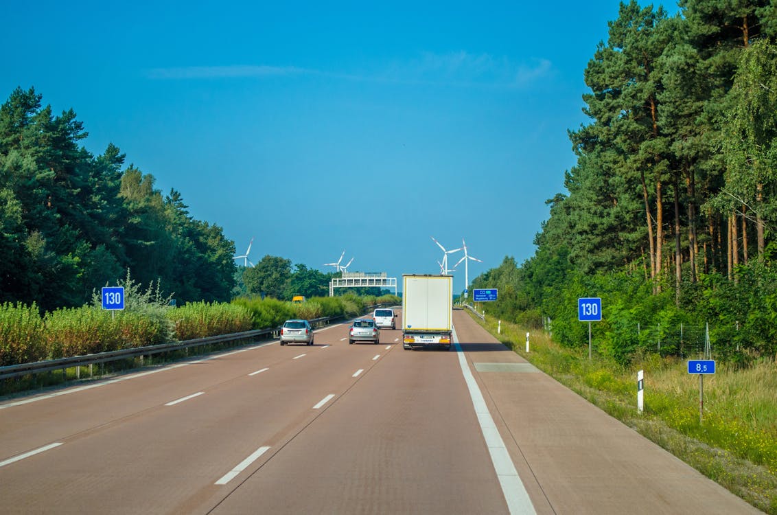 Free Vehicle Driving on Freeway Towards Wind Turbines Stock Photo