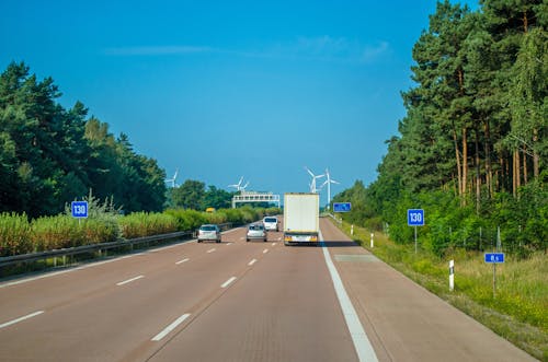 Free Vehicle Driving on Freeway Towards Wind Turbines Stock Photo