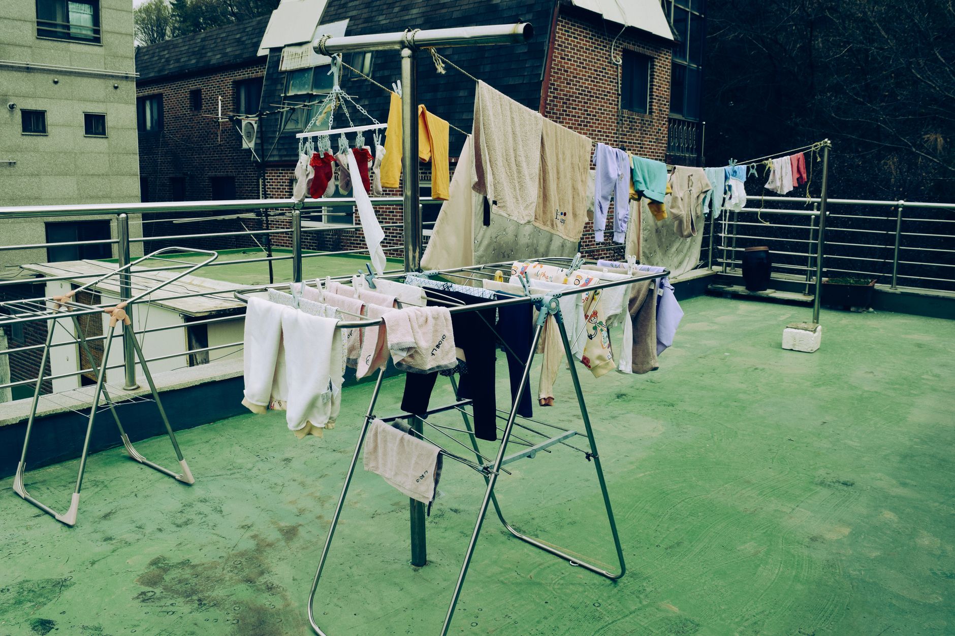 A rooftop scene with colorful laundry drying on a clothesline in an urban area.