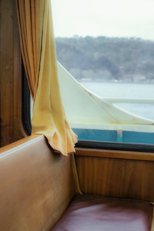 A view of a train window with curtains