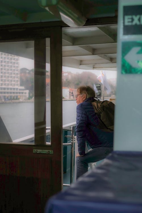 A man is looking out of a window on a boat