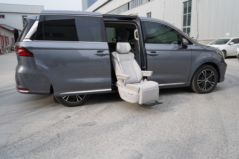 Gray luxury minivan featuring an open door with reclining seat