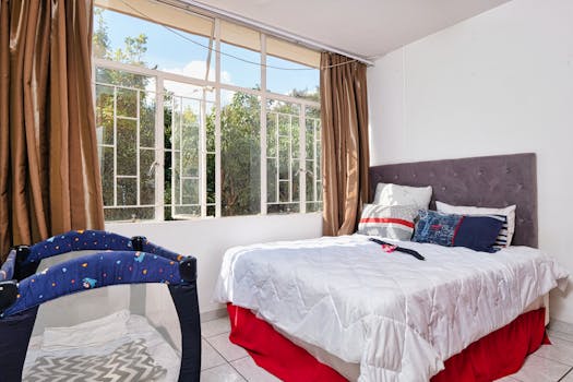 Sunlit bedroom with comfortable bedding and garden views for a cozy retreat.