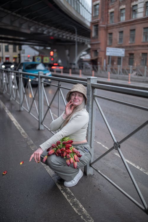 Free A woman is sitting on the ground with flowers Stock Photo