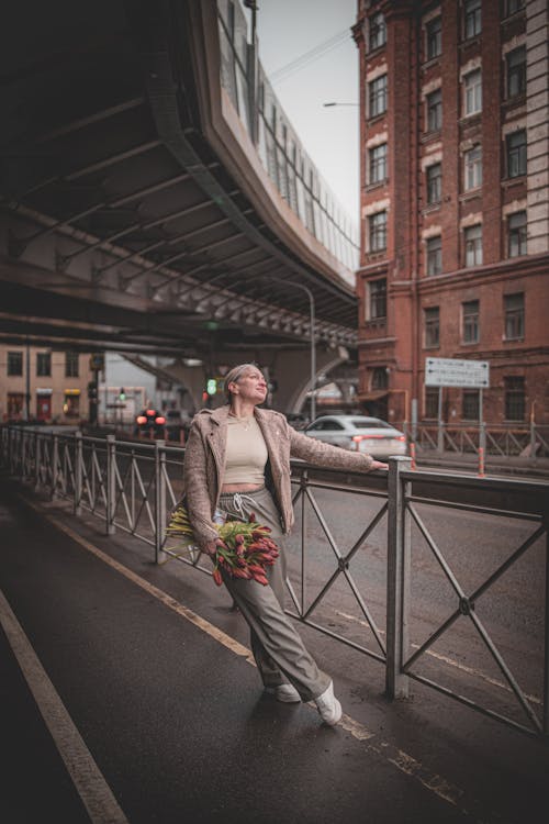 A woman standing on a bridge with flowers