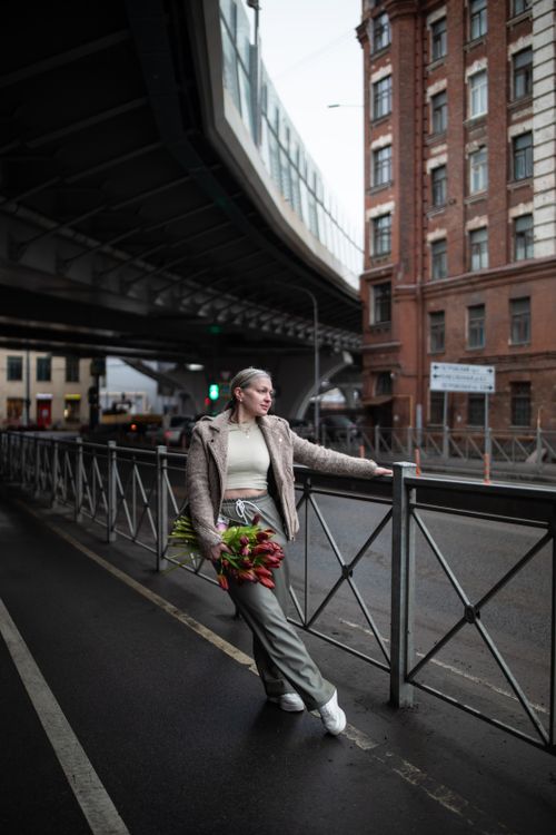 Free Stylish woman holding a bouquet on a city street, exuding confidence and elegance. Stock Photo