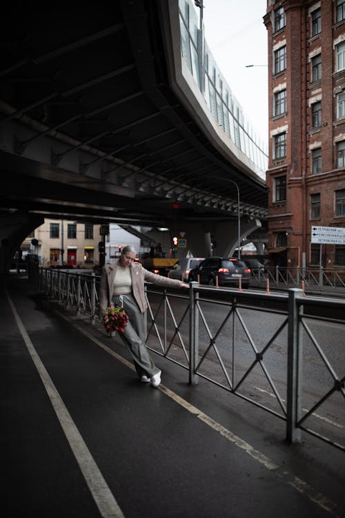 A woman on a skateboard is walking on the street