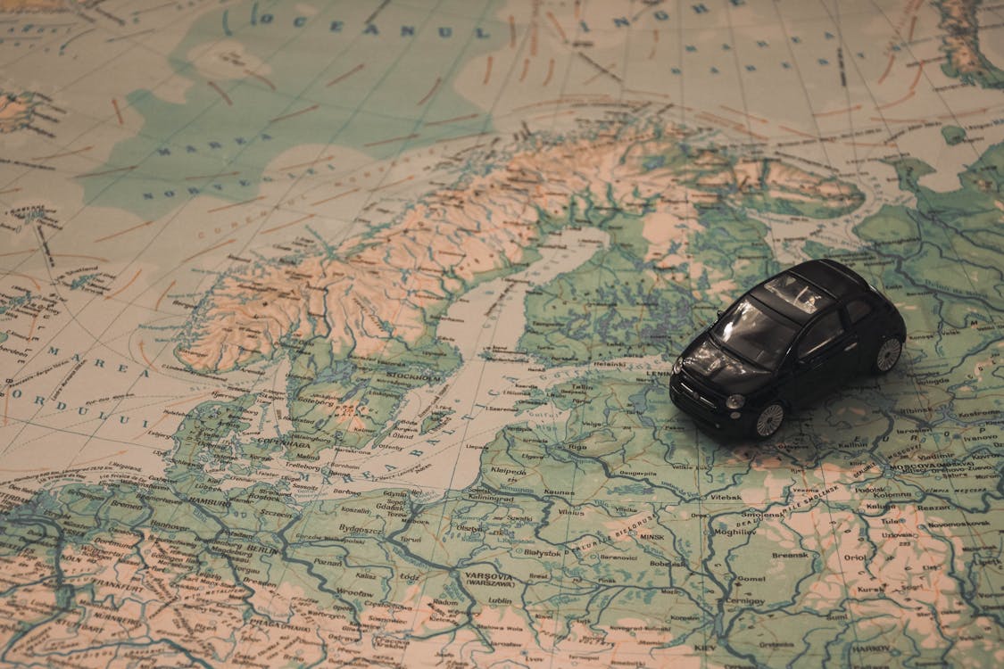 Black Toy Car on World Map Paper