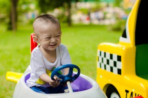 Boy Smiling While Riding Ride-on Toy