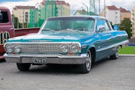 一辆经典的复古蓝色雪佛兰车停在城市背景的户外