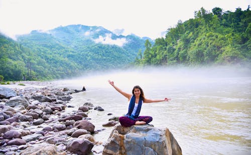 Foto De Mujer Sentada Sobre Piedra Junto Al Cuerpo De Agua