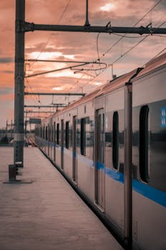 Photo by Febi Ariyanto A sleek modern train waits at a railway platform during a vibrant sunset, showcasing public transportation.