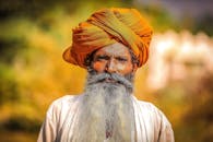 一位戴着传统橙色头巾、留着长胡子的老人，肖像充满活力