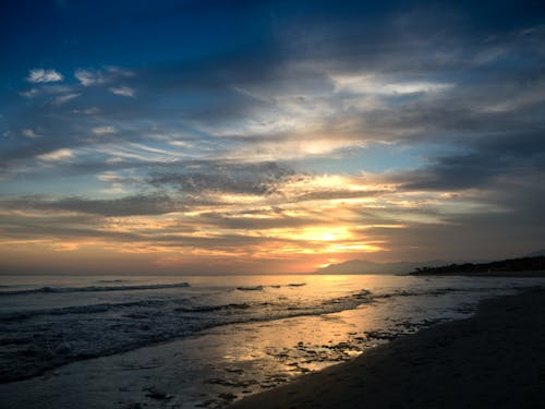 бесплатная Белый песчаный пляж во время Золотого часа Стоковое фото