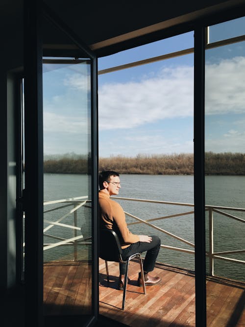 Free Man in Sweater Sitting by Rail Stock Photo