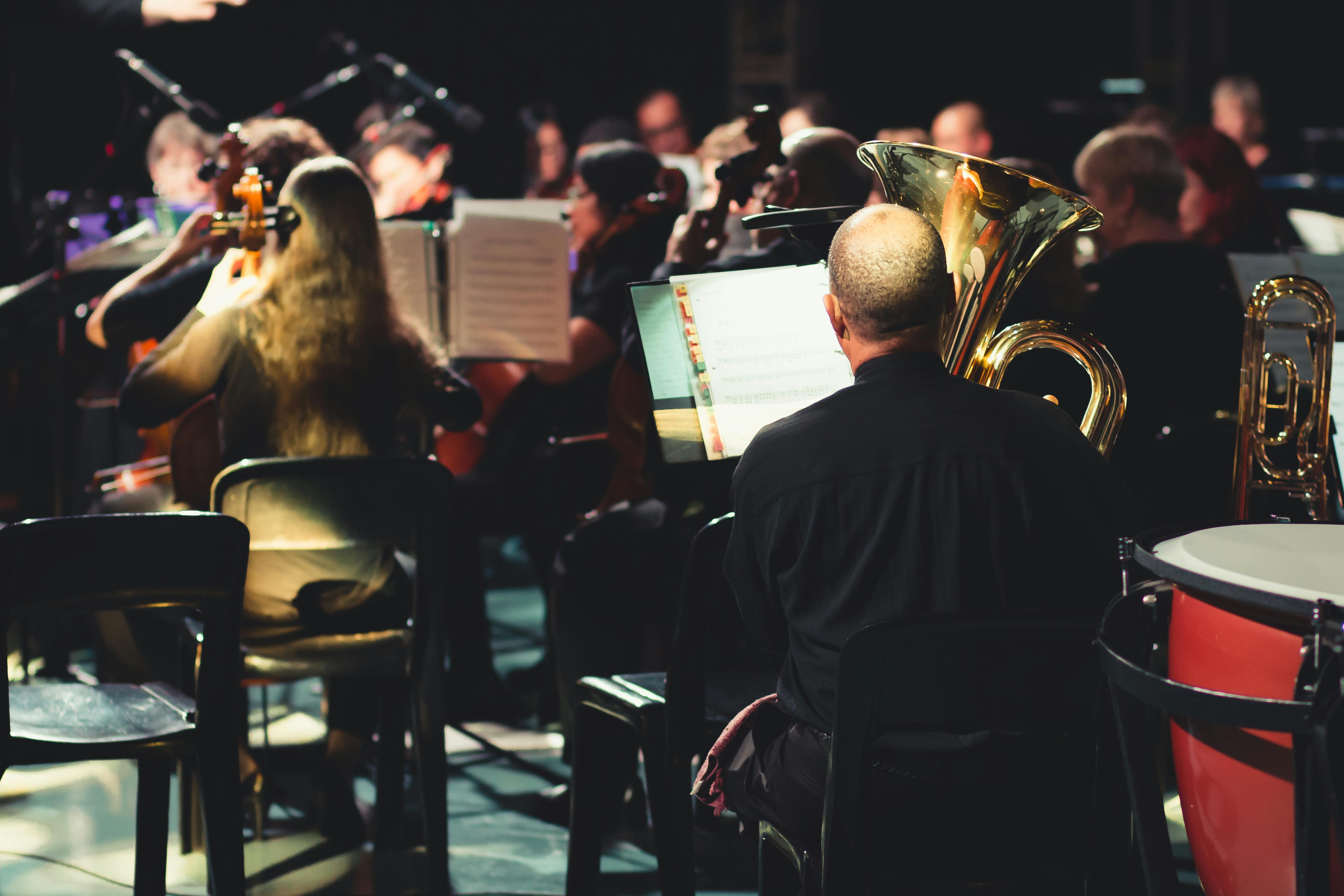 Audience watching a symphony orchestra from the balcony of a concert hall