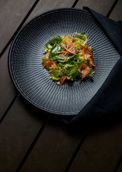 这道充满活力的蔬菜沙拉装在时尚的黑色盘子里，是健康用餐的理想选择