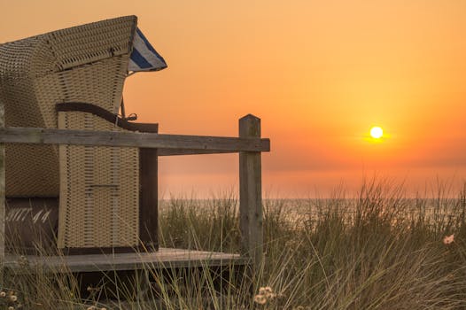 日落时分，宁静的海滩与柳条椅捕捉了自然之美和静谧