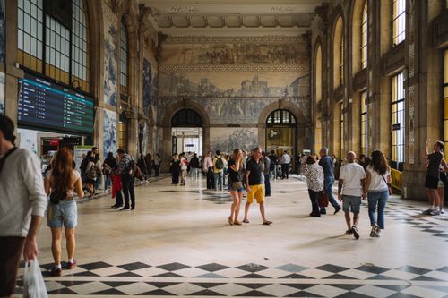 Free Gothic architecture of São Bento train station with tourists and locals exploring the hall. Stock Photo