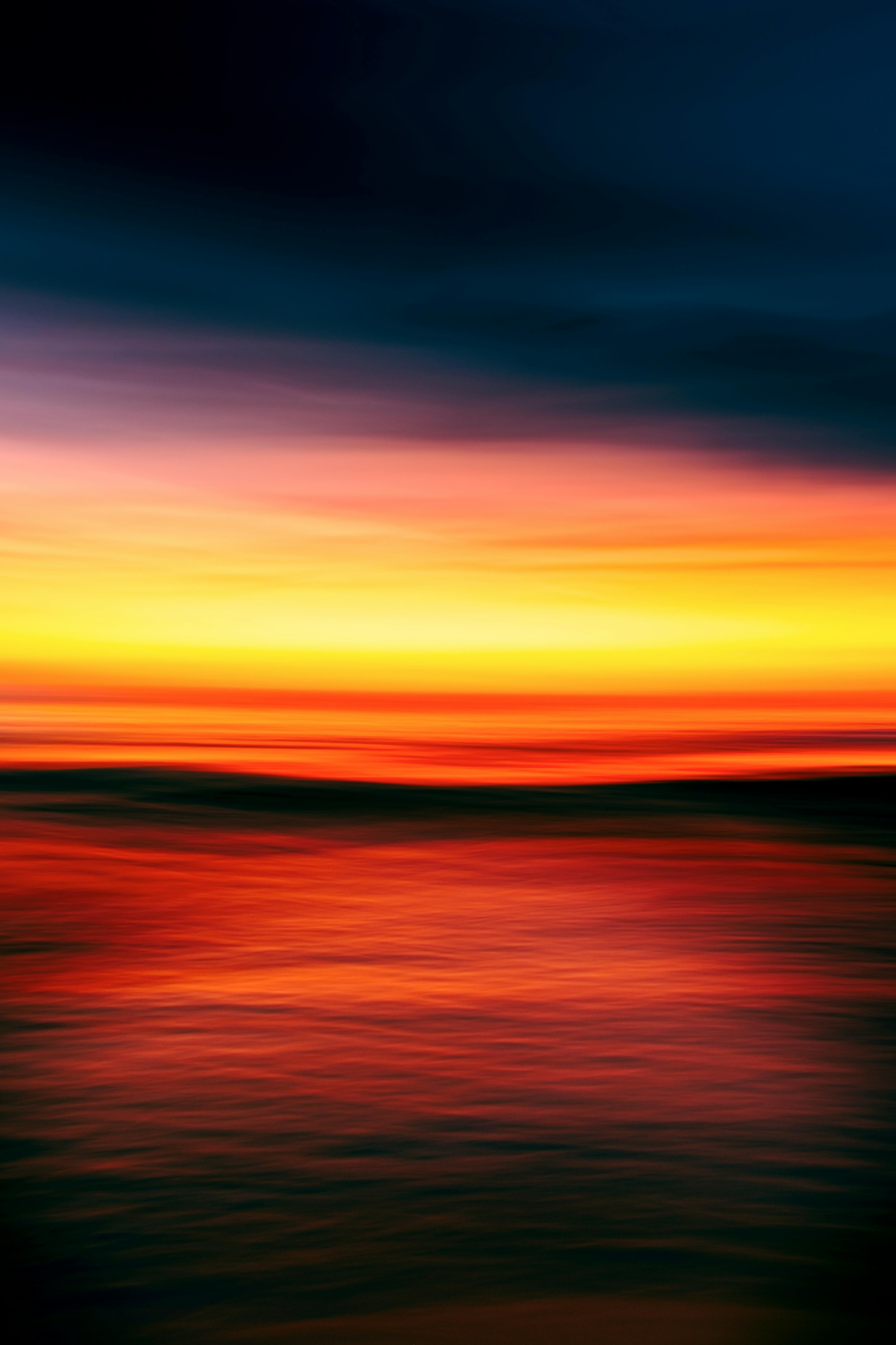 A serene and colorful abstract depiction of a sunset over the ocean, creating a tranquil seascape.