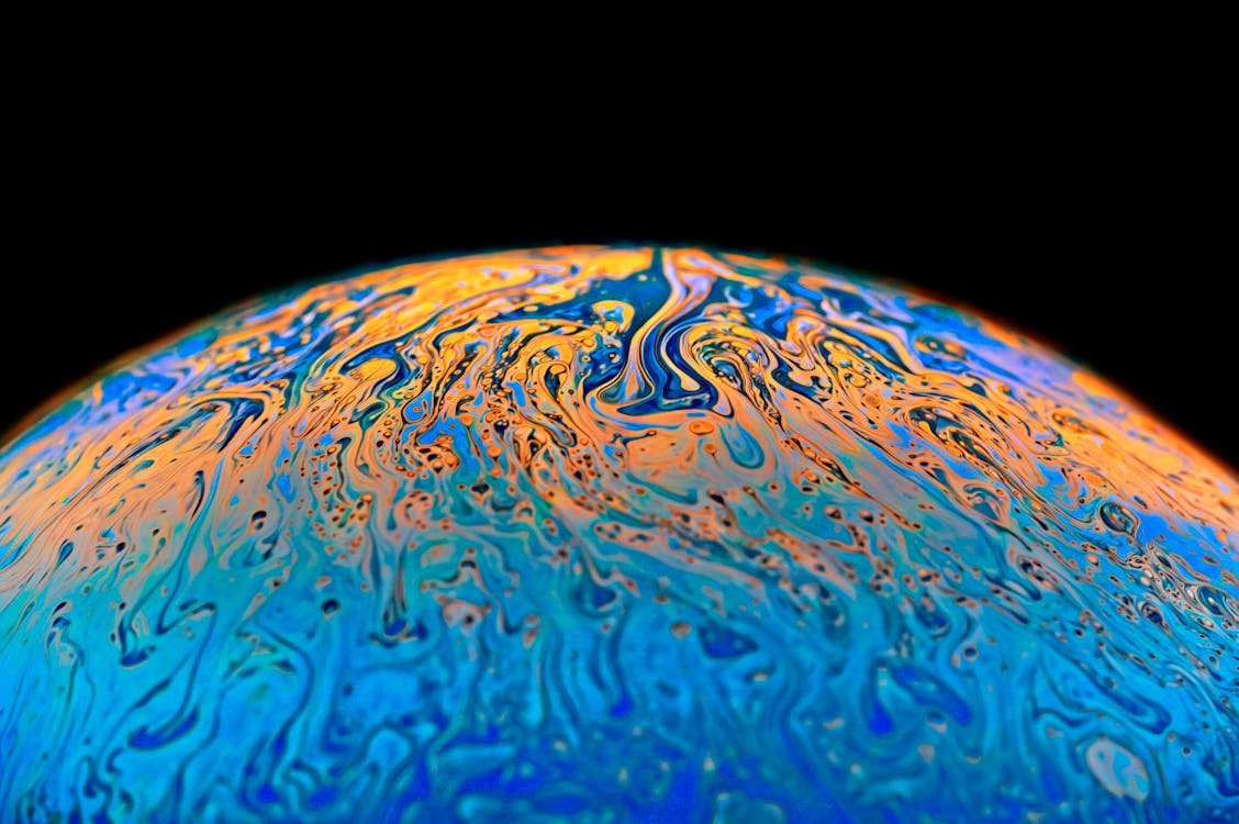A close up of a blue and orange colored planet