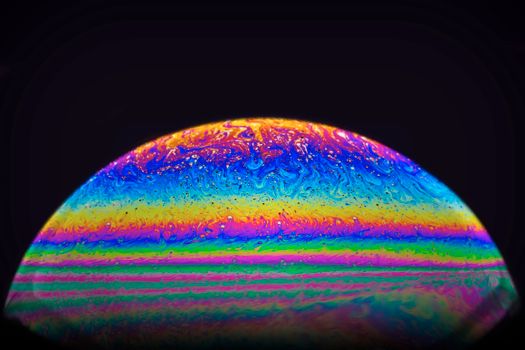 Vibrant swirling sphere resembling a cosmic globe with rainbow colors.