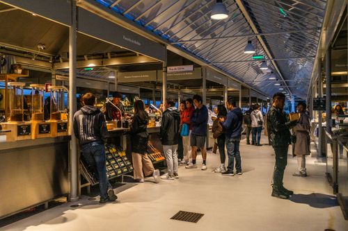 Free People shopping at an indoor market in Porto, Portugal. Vibrant atmosphere with diverse stalls. Stock Photo
