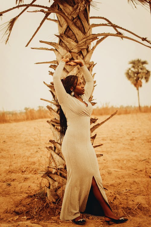 Woman Standing with Arms Raised under Tree