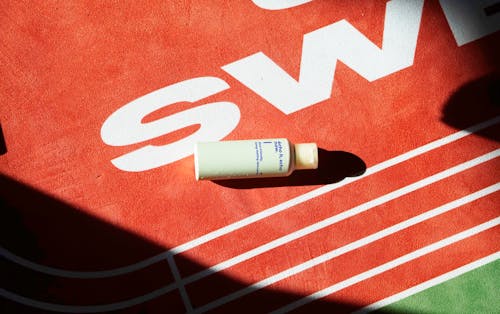 A bottle of toothpaste on a red and white track