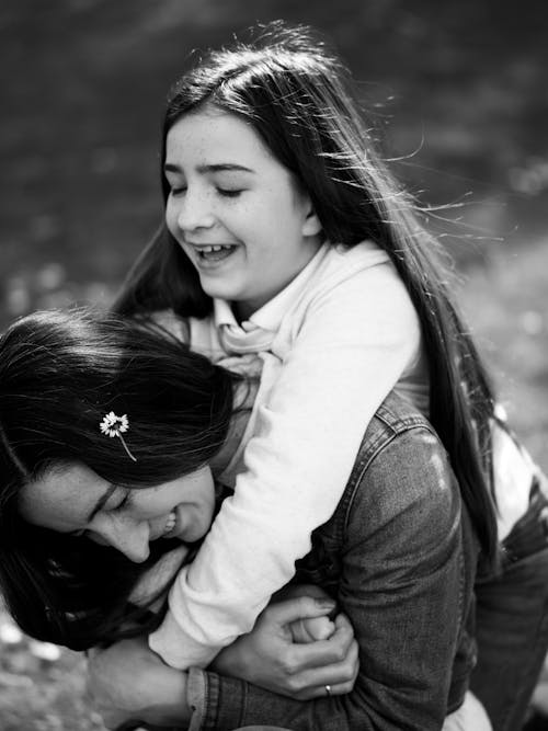 A black and white photo of a woman hugging her daughter