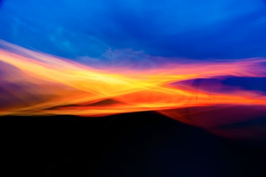 Dynamic and vivid abstract depiction of sunset hues blending across the sky.
