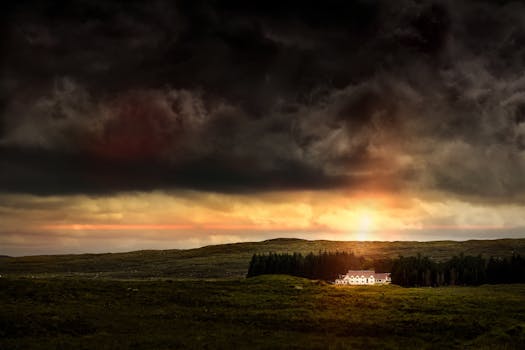 A stunning sunset over the Scottish Highlands with dramatic clouds and a distant house.