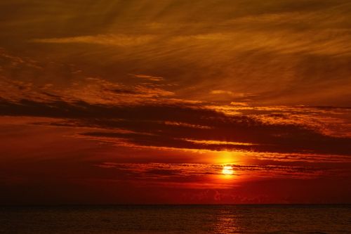 Free Breathtaking sunset view with vibrant sky over calm ocean, ideal for serene and warm themes. Stock Photo